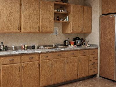 Kitchen before renovation showing outdated cabinets